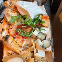 Board of cheeses, pastrami, mozzarella, bread and pizza at Retrogusto Experience in Lisbon