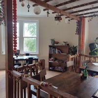Upstairs seating area with books and games at The Chakra Lounge in Bakewell