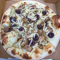 Pizza with cashew cream sauce, mozzarella, artichokes, mushrooms, olives and vegan sausage! Delicious.  at Plant Craft Kitchen in St Louis