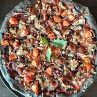 Vegan Pizza with black crust and cherry tomatoes at Black Crust Pizzeria in Vik