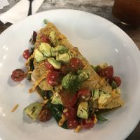 Vegan omelette (filled with mushrooms, spinach and dried tomatoes) topped with cherry tomatoes, avocado and a tofu sauce!   at Howme in La Paz