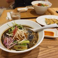 Black sesame ramen, with gyoza in background. at T's Tantan - Tokyo JR Station in Tokyo