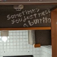 Cute sign above the hallway to the bathroom at Qué Pasa - Downtown in Kyoto