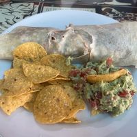 Burrito with brown rice, red and black beans, avocado and salsa served with guacamole and chips  at Casa Hood in Banos