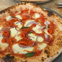 The Sgt.Peppers pizza: san marzano tomato base, fresh basil, fior-di-latte mozzarella, fresh red onion, peppadew peppers, topped with extra virgin olive oil. at Martin Bros in Leicester
