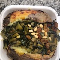 Jacked potato with pine nuts, fava cream, cicoria and raisins  at Poormanger in Milan