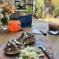 White bean & mushrooms bagel with fresh salad on the side and cold brew coffee    at Alma Mia Deli in Puerto Escondido