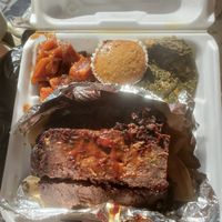 Vegan Meatloaf with sides of glazed yams, greens, and a muffin. at Jack it Up Vegan Eats in Rockford