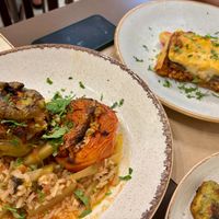 Roasted tomato/pepper dish with rice, vegan moussaka, and a hint of zucchini balls in the corner at Diporto in Corfu