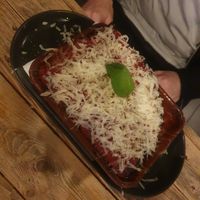 Homemade lasagna with a rich tomato, lentil and soya ragù, grated parmesan cheese, evoo at Ortica Italian Plant Based in Urmston