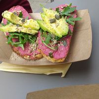 Beetroot hummus on sourdough toast with avocado, rocket and seeds at Squeezee in Barmouth