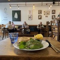 Vegan bagel and backdrop of the cafe   at Kalipso Artisan Coffee in Torquay