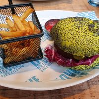 Vegan burger in a very green poppy seed bun with a portion of fries at Love Lane Brewery in Liverpool
