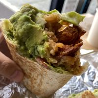 Al Pastor, Guac Sour, Creme, Lettuce, Tomato, Rice, Beans inside.  at Rojos Mexican Food in Seattle