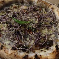 Vegan pizza with potato cream, vegan cheese, veggies and crispy fried potatoes on top at Pizzaria Criscemunno in Salerno