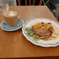 Latte et délicieux pancake sirop d'érable, beurre de cacahuète et fruits. at Ground to Grow in Paris