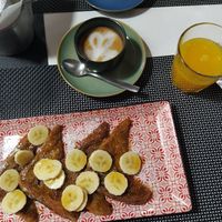 French toast with maple syrup and banana, oat milk cappucino and orange juice at Caffè dell'Arte Specialty Coffee in Cagliari