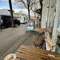 Three low ice cream tables indoors and two sidewalk tables outside    at Nuttea in Vancouver