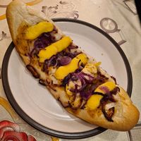 Baguette topped with red onion and cheese at De Vegan Bakker in Heusden