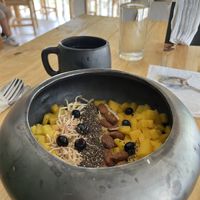 Mango frappe made with coconut milk covered with fresh mango, pineapple, chia seeds, almonds, coconut, and berries  at Romero in Huatulco