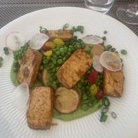 Grilled tofu with creamy pea purée, spring onion green pea ragout, and potatoes baked in jacket...  at KÜVÉ Bisztró és Borbár in Eger