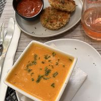 Cup of the special carrot/ginger soup; vegan arancini cakes with spicy sauce.  at Vegan A.F. in Brattleboro