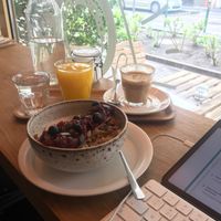 coconut yoghurt bowl, flat white (that i took some sips from already, so good) and fresh (but bottled) orange juice  at Fanka Budapest in Budapest