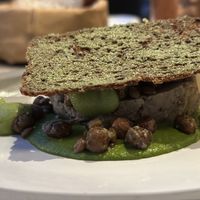 Rye bread Cruton atop parsley and baby caper dish  at ansvar - Greenery Lab in Copenhagen