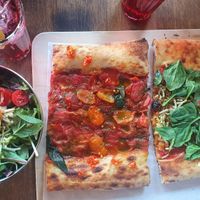 Two different vegan pizza slices and salad at VITO Europaallee in Zurich