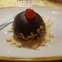 Chocolate desert, a kind of chocolate mouse inside and some red fruit sweetness. at I Morgante Bottegabistro in Agrigento