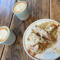 Flat white coffees and almond croissant   at Fire & Flow Coffee Roasters in Cirencester