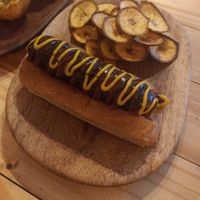 Plantidog-er bratwurst: vegan sausage with mustard sauce & bbq sauce. Plantain chips on the side at Vegano O No in Panama City