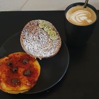 Latte, tomato and olive bread and a pistachio cream filled bun at The Sanctuary in Berlin