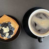 Blätterteigteilchen mit einer Creme an Vanille/ Caramel erinnernd, verziert mit Blaubeeren und Brombeeren. Dazu einen Americano.  at The Sanctuary in Berlin