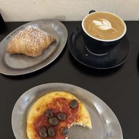 Vanilla croissant, flat white and a tomato sauce and olive mini-pizza  at The Sanctuary in Berlin