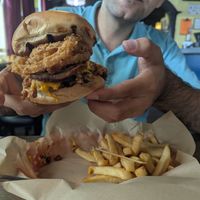 Andy showing his yummy cowboy burger at Bean Vegan Cuisine in Charlotte