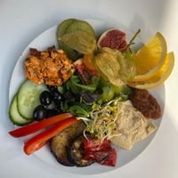 Mediterranes Frühstück mit Ciabatta, Kräuter-Oliven, Grillgemüse, Hummus, Tomatenbutter, Pesto, Rohkost und Obst  at Café Warenannahme  in Hannover