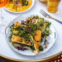 FOCACCIA AUBERGINE
Focaccia aubergine grillée, tomates séchées, pesto de cerfeuil, crème de balsamique, roquette et mozzarella, servie avec salade

Possibiilté feta vegan at La Luck in Brussels