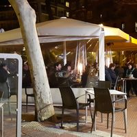 Outdoor seating in a tent at Café Bar Arco Iris in Madrid