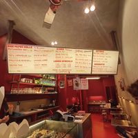 The menu on the screen at Knees to Chin in Louvain-la-neuve