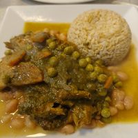 Seco de cabrito - cilantro stew with soy meat, marinated in natural spices, served with beans, brown rice, and salsa criolla. at Sazon Del Muya in Trujillo