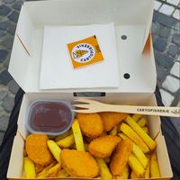 Vegan nuggets, chips, and a pot of ketchup, in a take-away box with a wooden fork at Cartofisserie in Brasov
