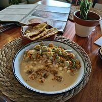 Ceviche con crispy tofu y patacones. Un libro de cocina Ecuatoriano en el fondo. at Agave Studio in Puerto Ayora