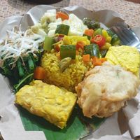My plate: tempeh, green beans, beansprouts, spinach, cabbage, courgette, carrot, caulilower, spicy sauce, tofu, fried tofu parcel with cabbage and beansprouts inside, turmeric rice at Warung Indonesia in Kuta