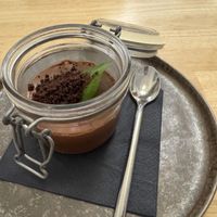 Ein cremiges Schokoladenmousse im Einmachglas, garniert mit Schokobröseln und einem frischen Minzblatt  at Ti's Café in Minheim
