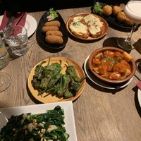 NOTE: back three dishes are not vegan or veggie. From the front, left to right: Espinicas a la Catalana, Pimientos del Padron, and Patatas Bravas. Not pictured: Berenjena Al Horno. at Tinto Taperia in Brighton
