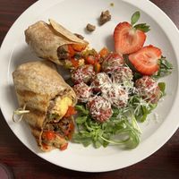 Vegan steak ‘n’ egg burrito with tomato salad  at The Hungry Pug Cafe in Kenora