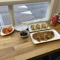 From left to right, yuzu tea, kimchi, dipping sauce, seaweed rolls with dumplings, veggie pancake    at MukBap in London