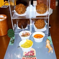 Petisco cachorro caramelo: bolinho de feijão fradinho com recheio de cogumelos, acompanha creme de abacate, vinagre e molho de dendê apimentado at Aflora Gastrobar in Brasilia