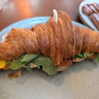 Croissant sandwich with fake meat and cheese at KŸNO in Brno